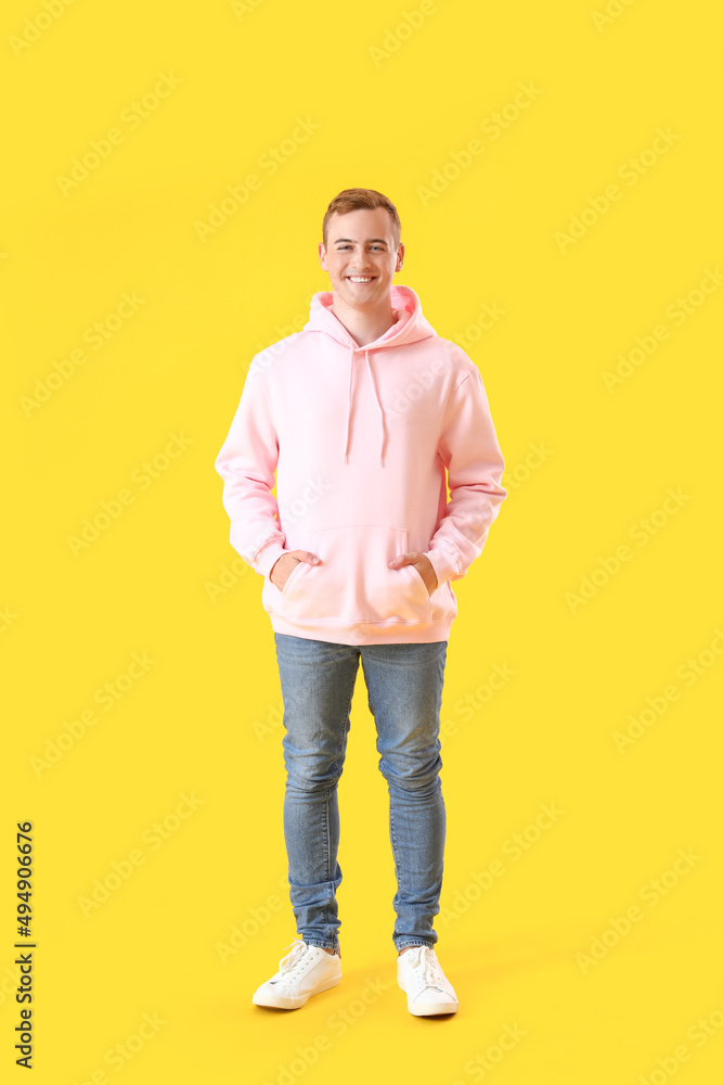 Young guy in stylish hoodie on color background