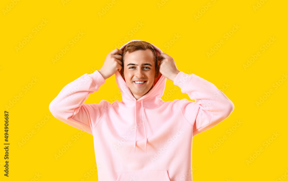 Young guy in stylish hoodie on color background