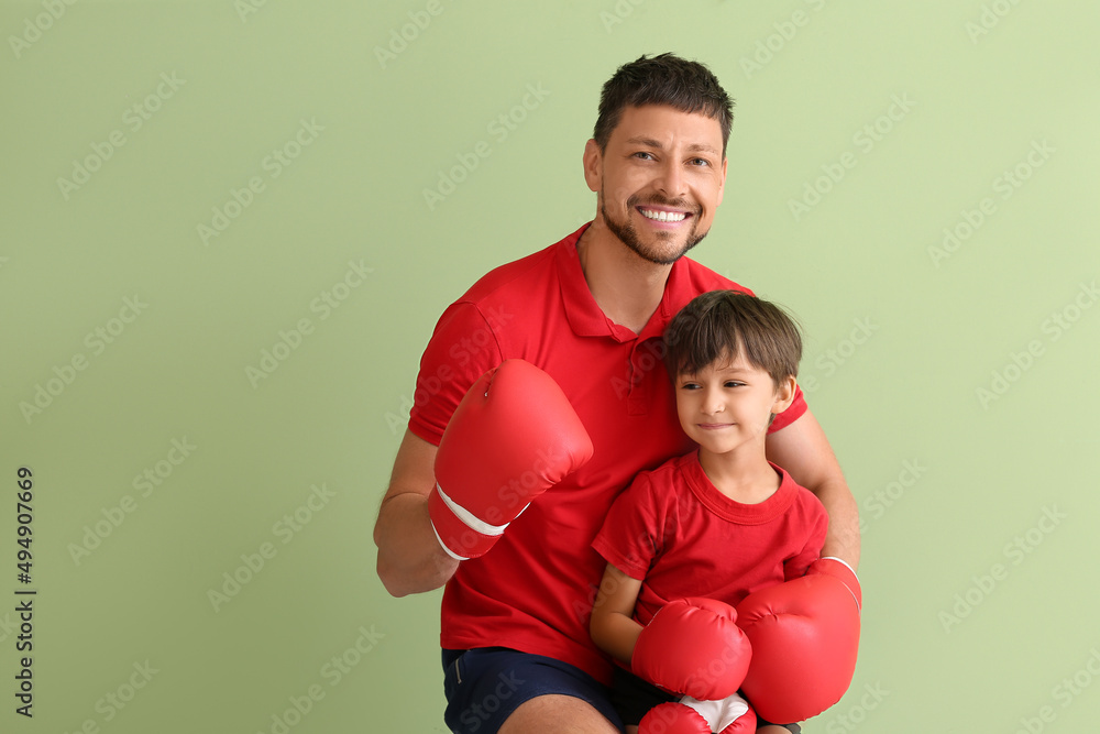 绿色背景下有拳击教练的小男孩