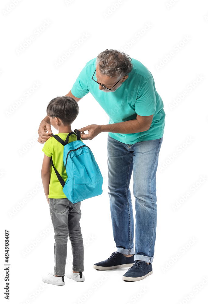 Senior man adjusting his grandsons backpack on white background