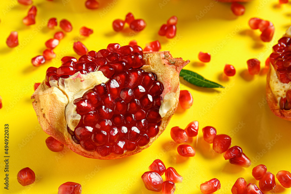 Tasty ripe pomegranate piece on yellow background