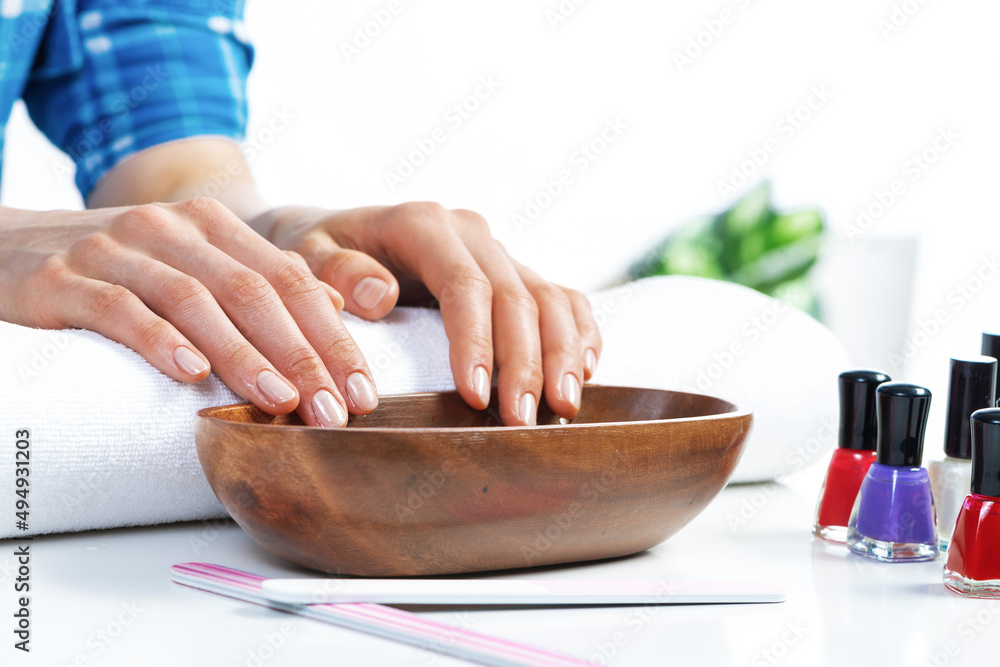 Closeup female hands in wooden bowl with water