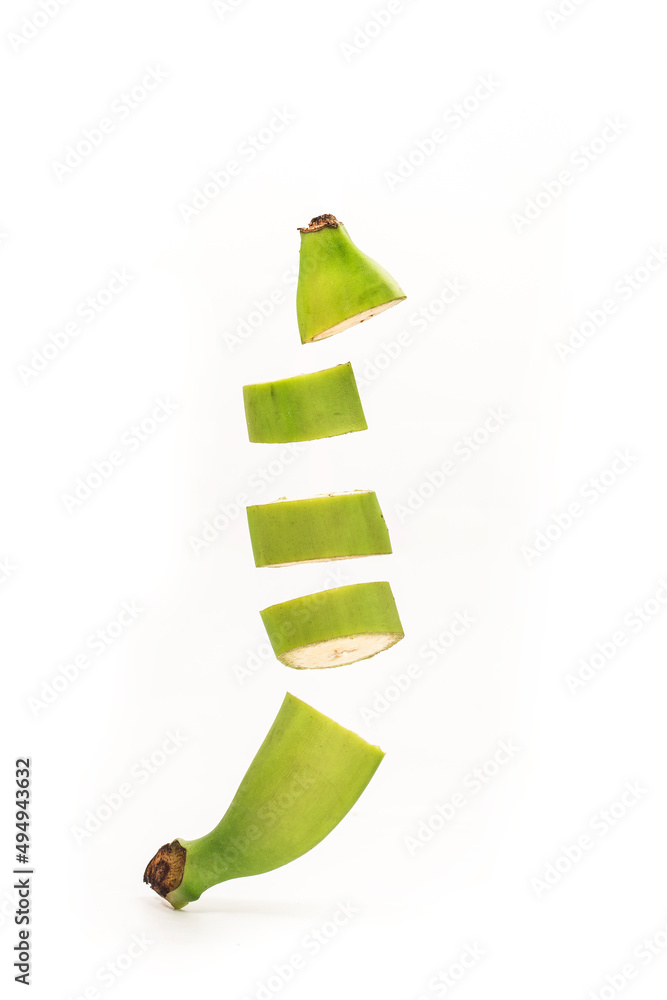 Whole bananas and slices are flying close-up on a white background.