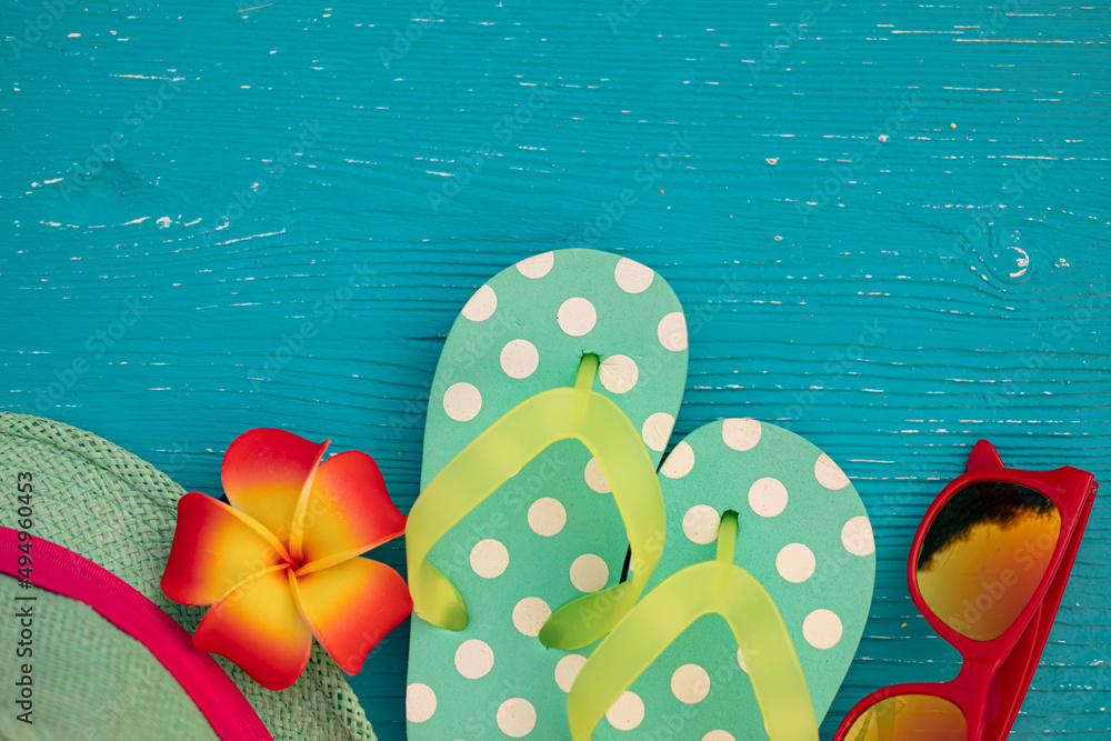 Beach flip-flops on blue wooden background