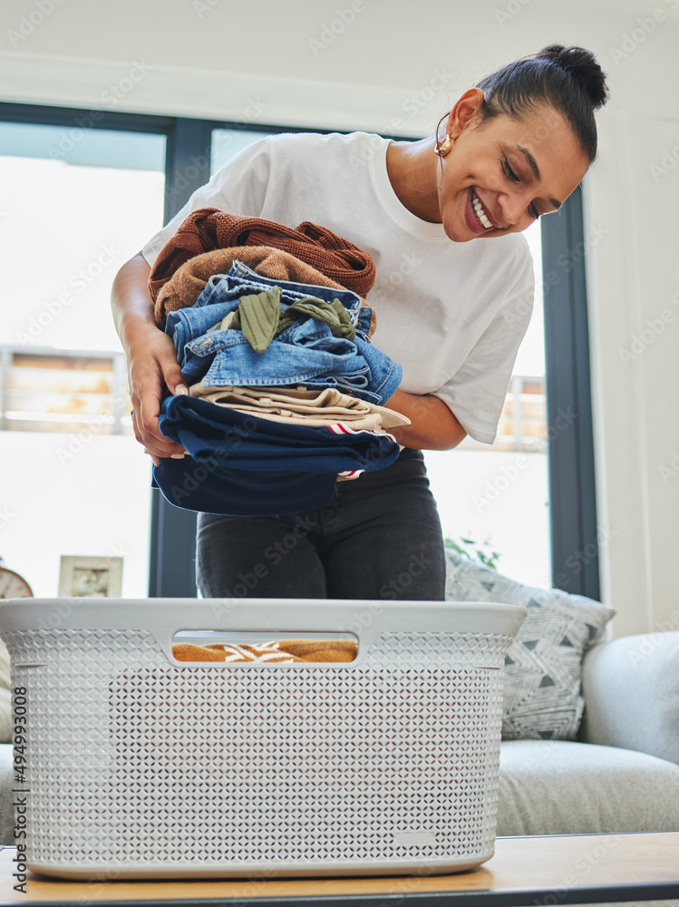 Neatly folded clothing is so satisfying. Shot of a young woman packing away clean laundry.