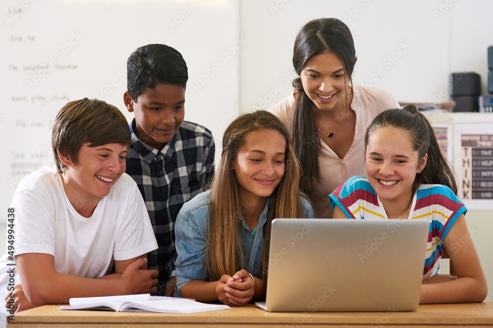 Using all the resources the internet has to offer. Shot of a group of schoolchildren using a laptop 