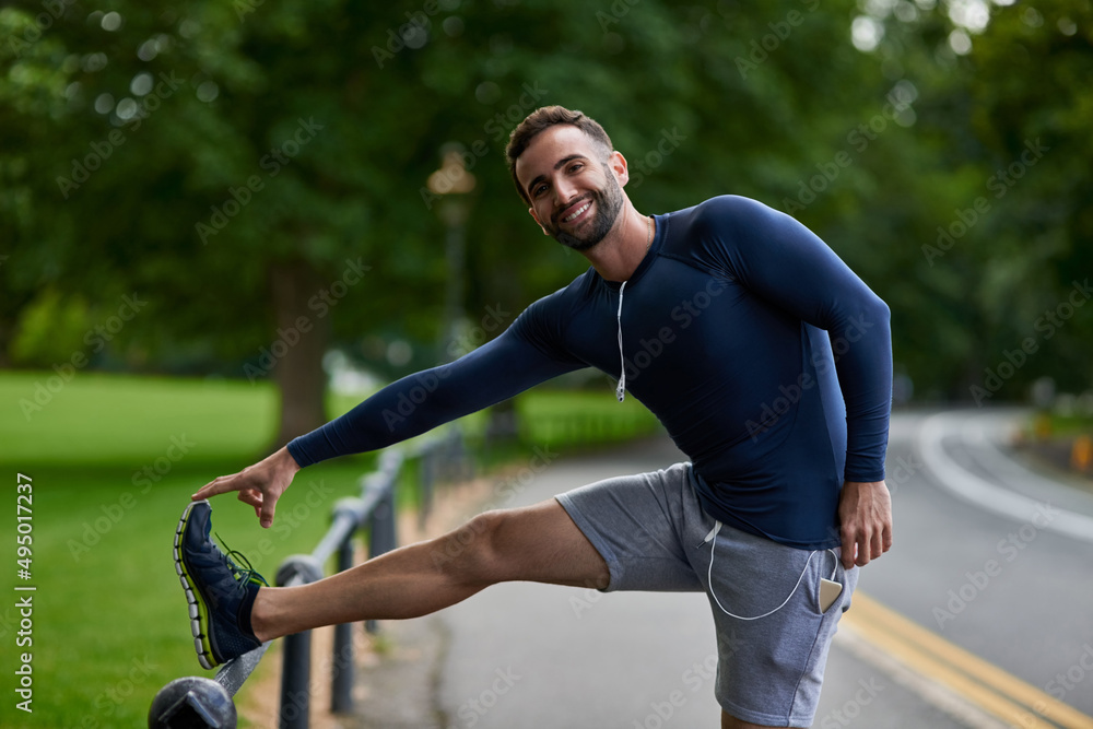 Dont forget to stretch. Cropped portrait of a handsome young male runner warming up before his worko