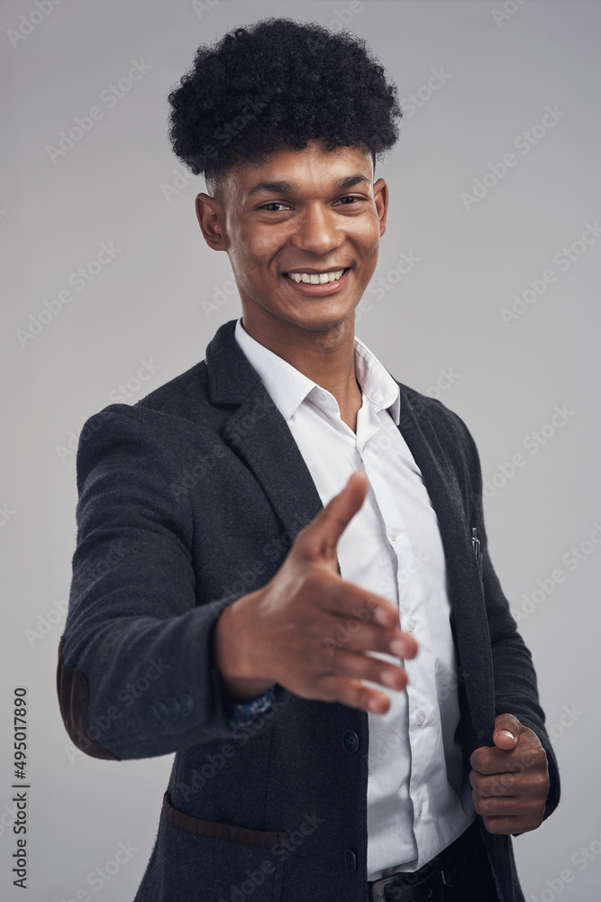 Pleased to make your acquaintance. Studio shot of a young businessman extending his arm for a handsh