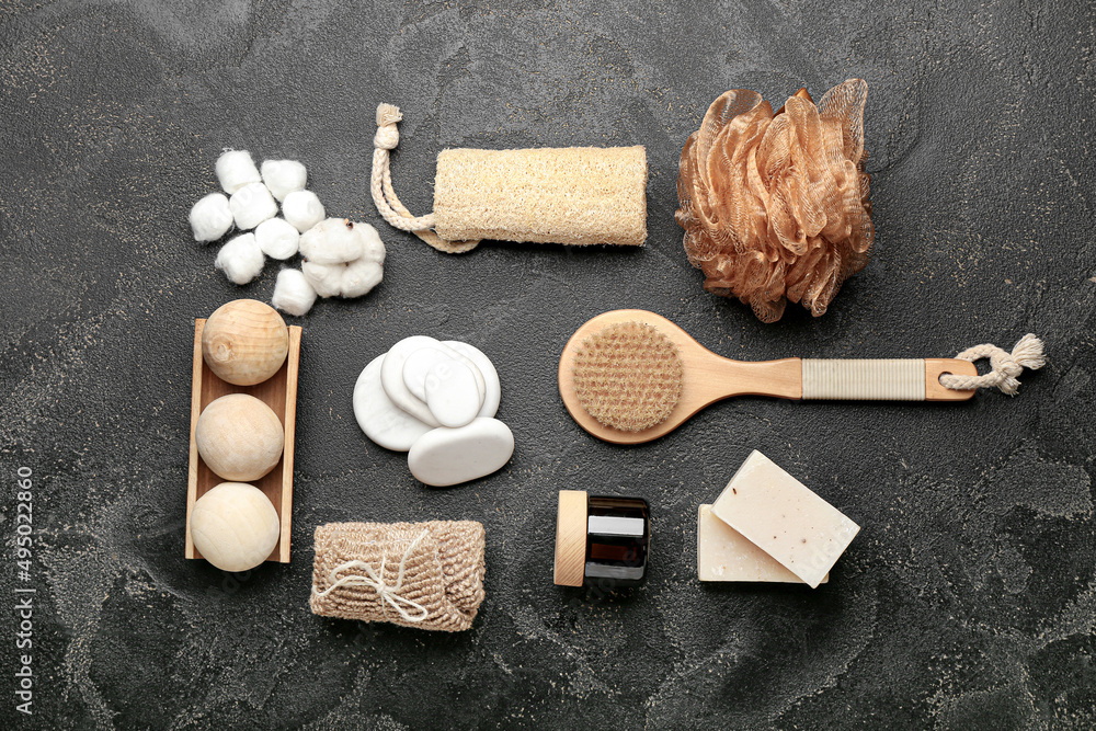 Bathing supplies with cosmetics and spa stones on dark background