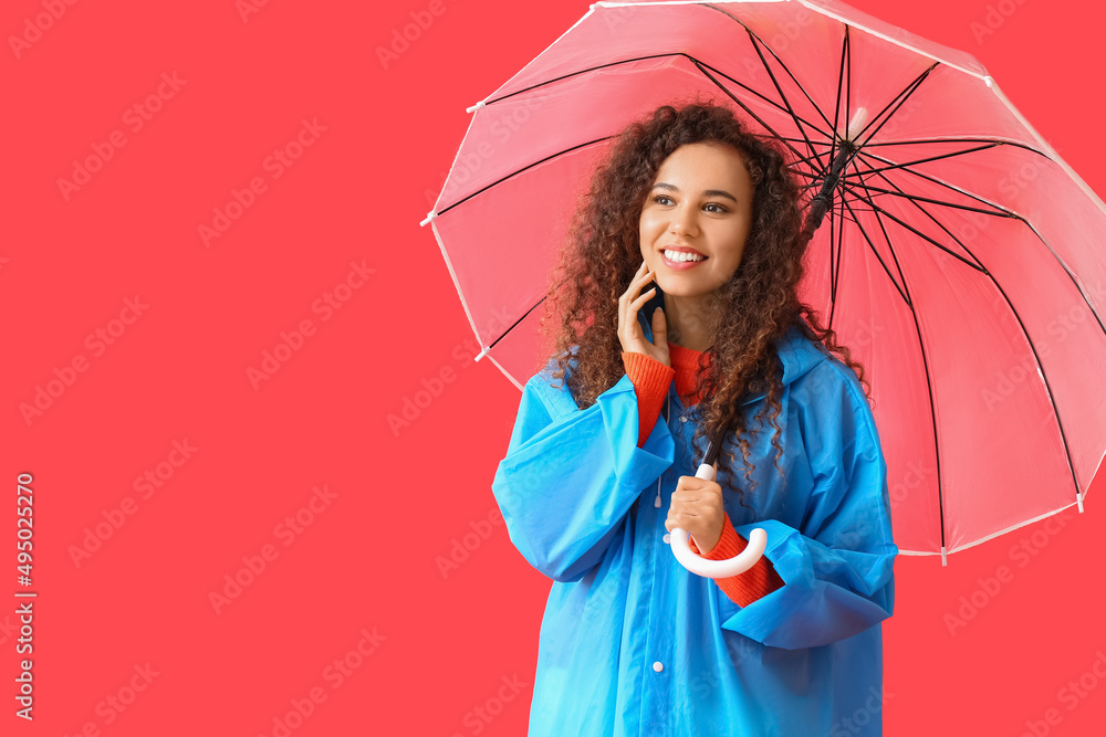 身穿蓝色雨衣、红底带伞的年轻非裔美国妇女