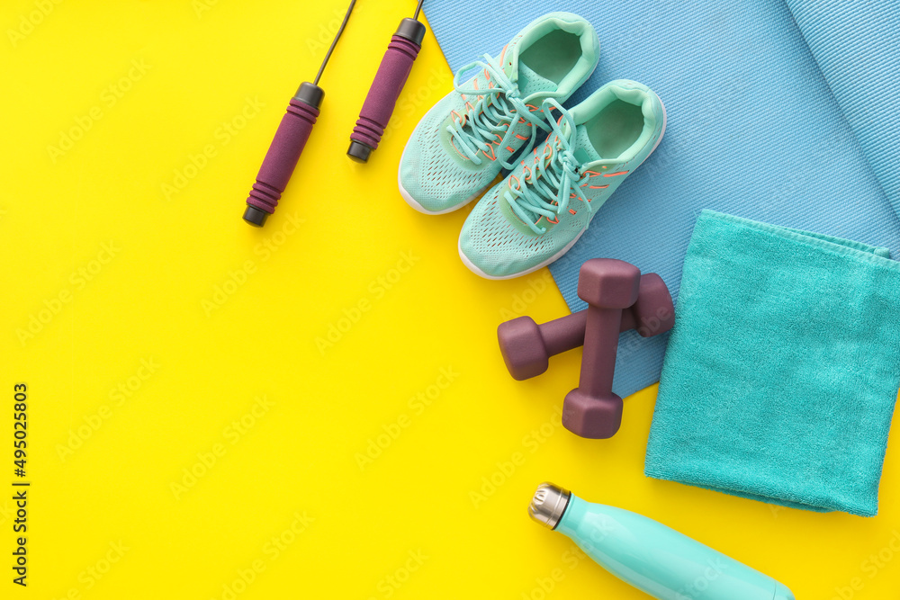 Different sports equipment and shoes on color background