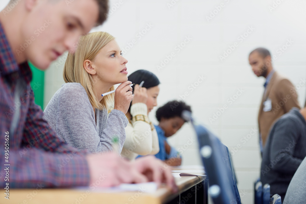 认真思考了她的答案……一群大学生写考试的镜头。