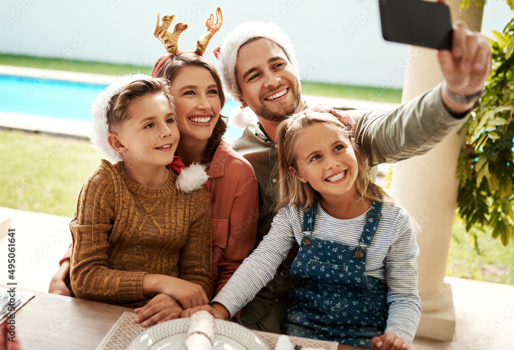 Were always ready for a Christmas selfie. Cropped shot of a family of four taking a selfie together 