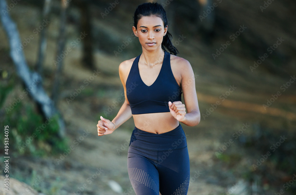 Tackling the trail with focus and confidence. Shot of a sporty young woman running outdoors.