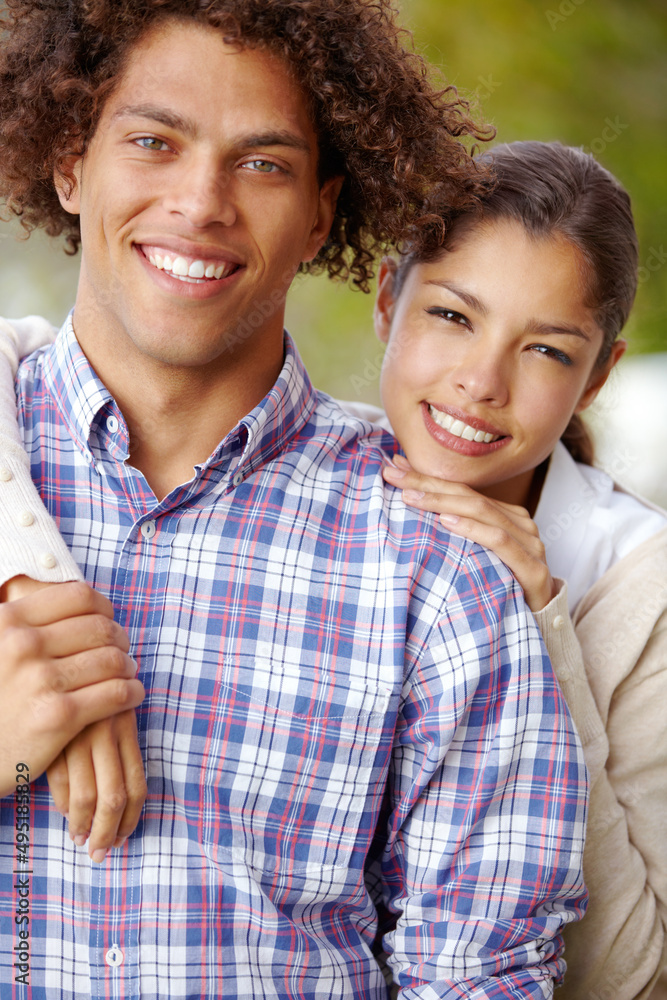 Committed to a loving future. Portrait of a beautiful mixed race couple smiling together outdoors.