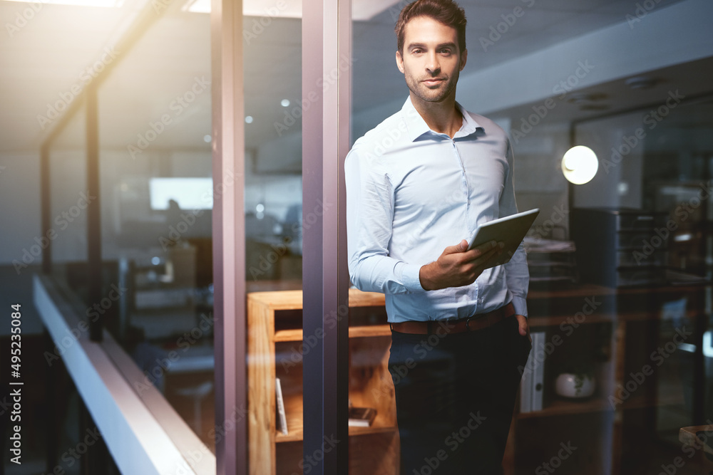 The web is his source of inspiration. Portrait of a young businessman working late on a digital tabl