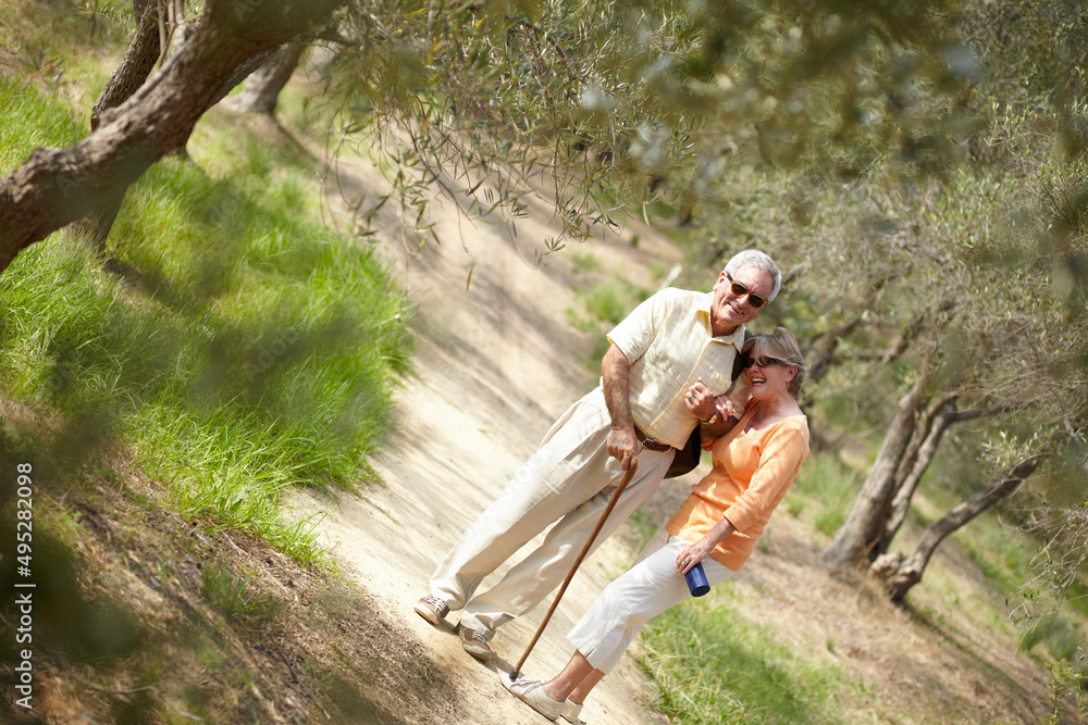 Enjoying a leisurely stroll through the woods. A senior couple walking together along a forest trail