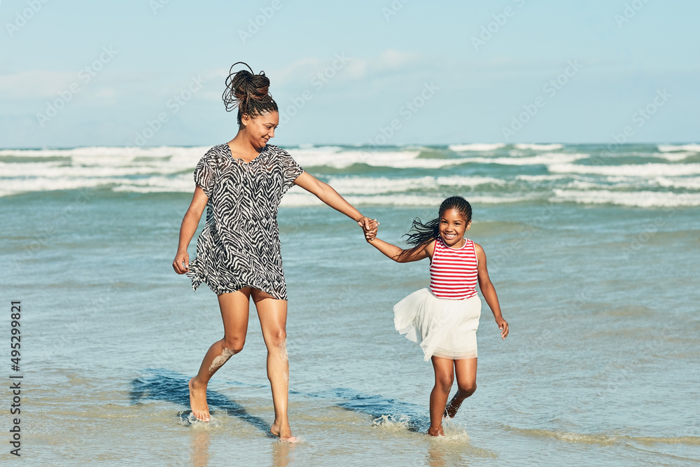 Sunny summer days are best spent at the beach. Shot of a mother and her little daughter enjoying a w