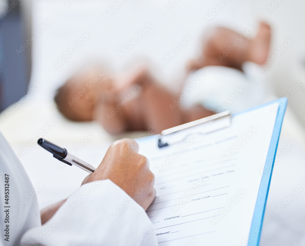 My littlest patients are the cutest. Shot of a doctor making notes about her infant patient on a cli