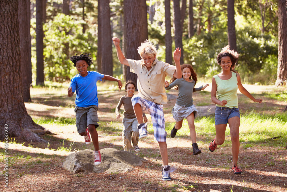 They enjoy the outdoors. Shot of a group of young kids enjoying themseves out in the woods.