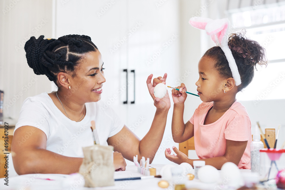 想象力会带你去任何地方。一位女性在家和女儿画鸡蛋的照片。