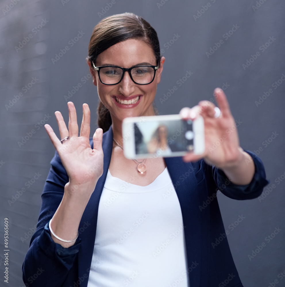 Hello social media, hello world. Shot of a happy businesswoman taking a fun selfie with her smartpho