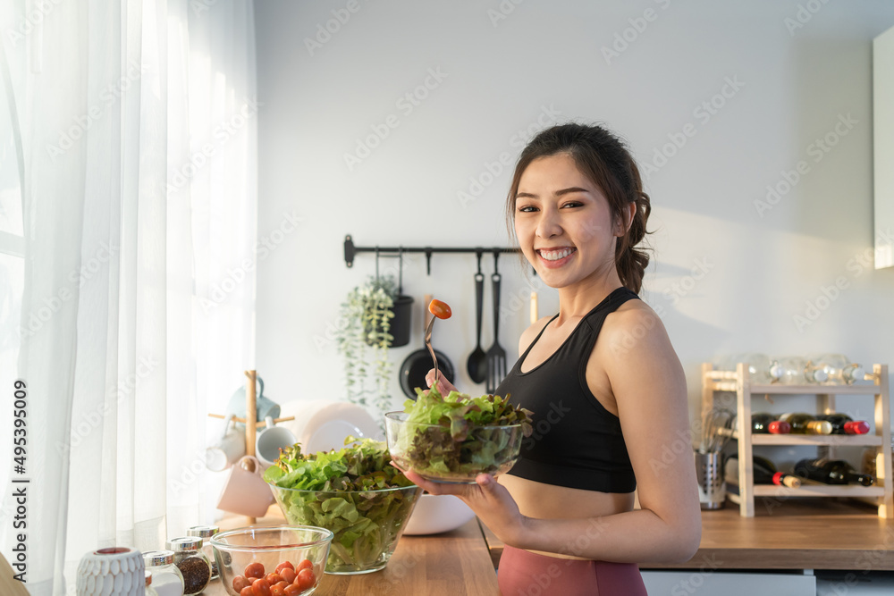 亚洲美女拿着沙拉碗看着镜头的肖像。