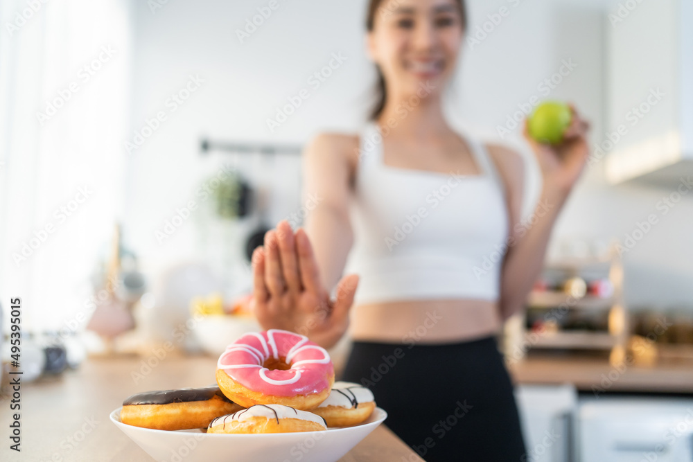 亚洲有魅力的活跃女性在家里的厨房里拿着青苹果。