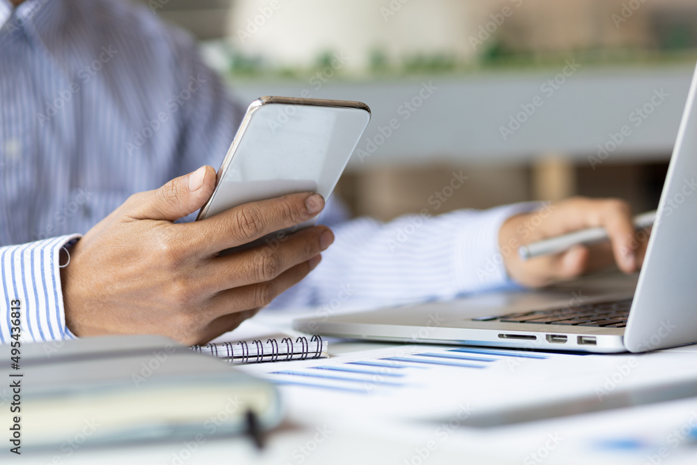 Close-up business man working on laptop and using mobile phone. Concepts of modern financial analysi