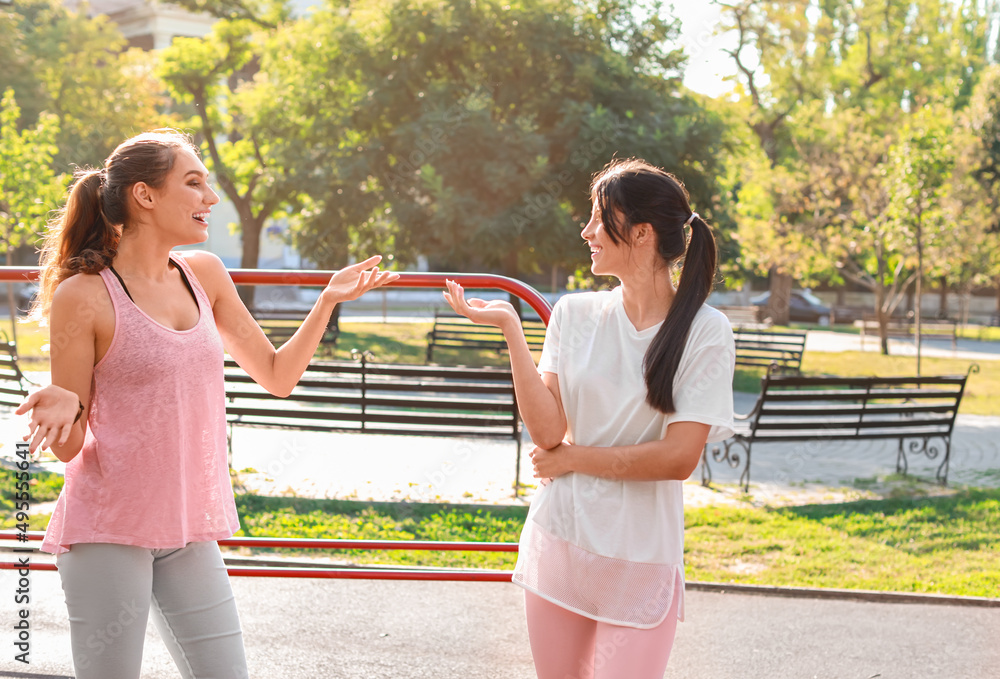 Sporty young women talking on sport ground