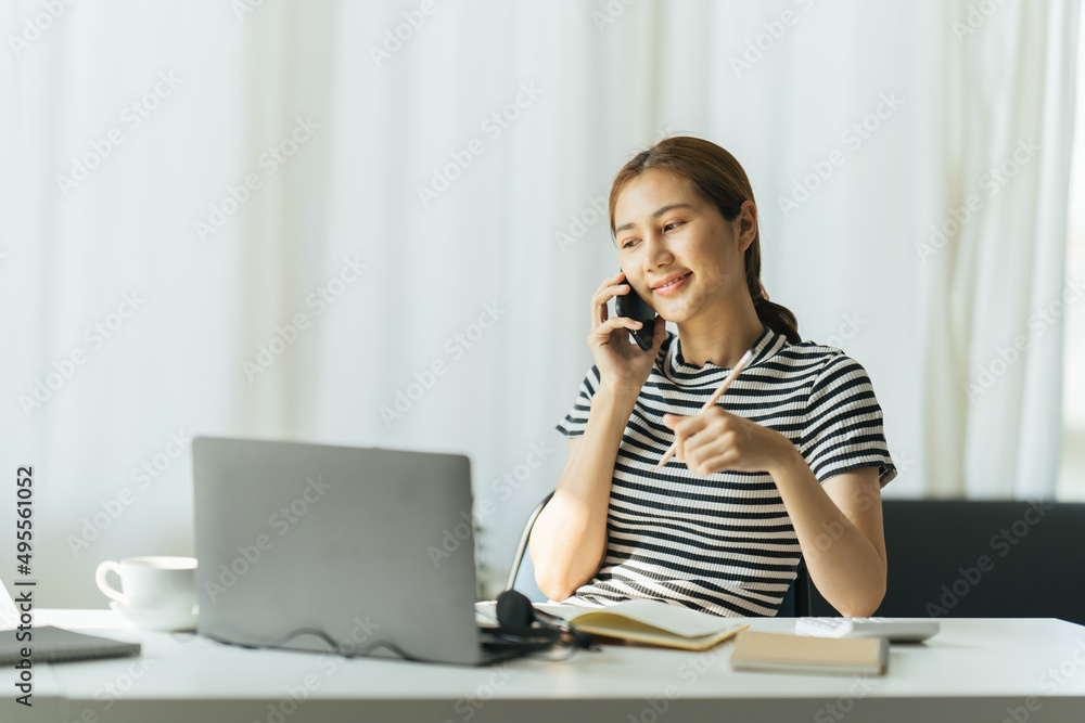 Asian young cheerful happy woman indoors at home at the home office using laptop computer talking by