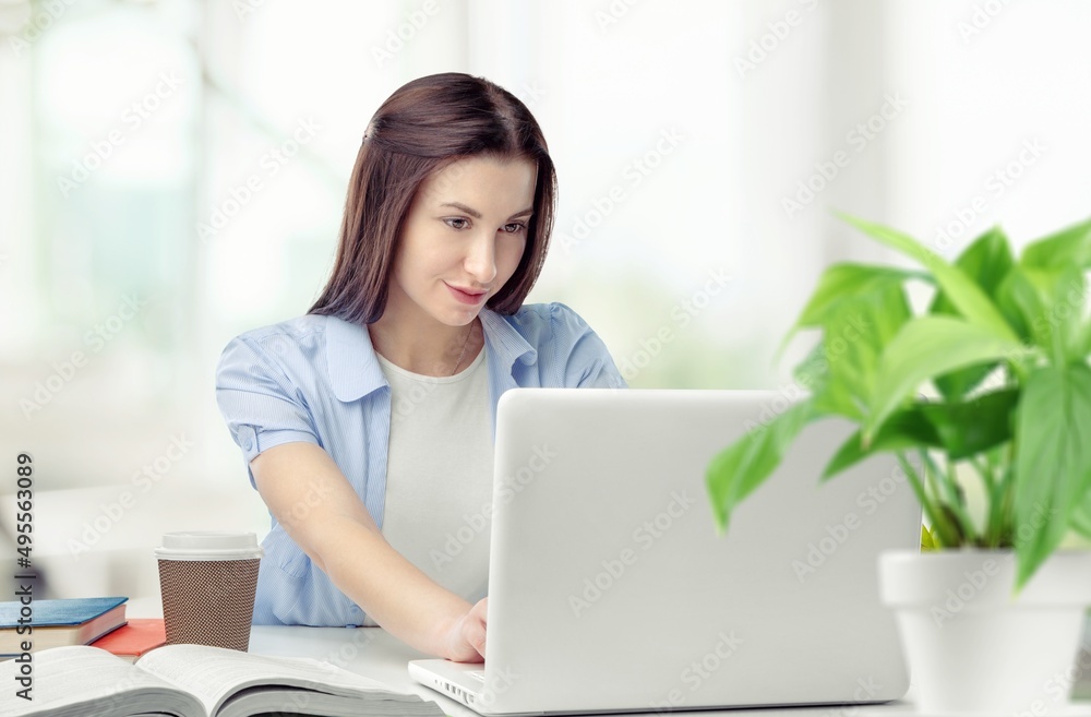 Distance Education. Portrait of smiling student sitting at desk, using laptop