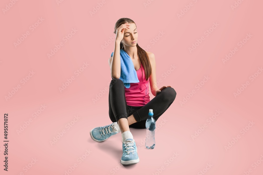 Young sporty athletic fitness woman woman spend time in home gym on pastel pink background. Workout 