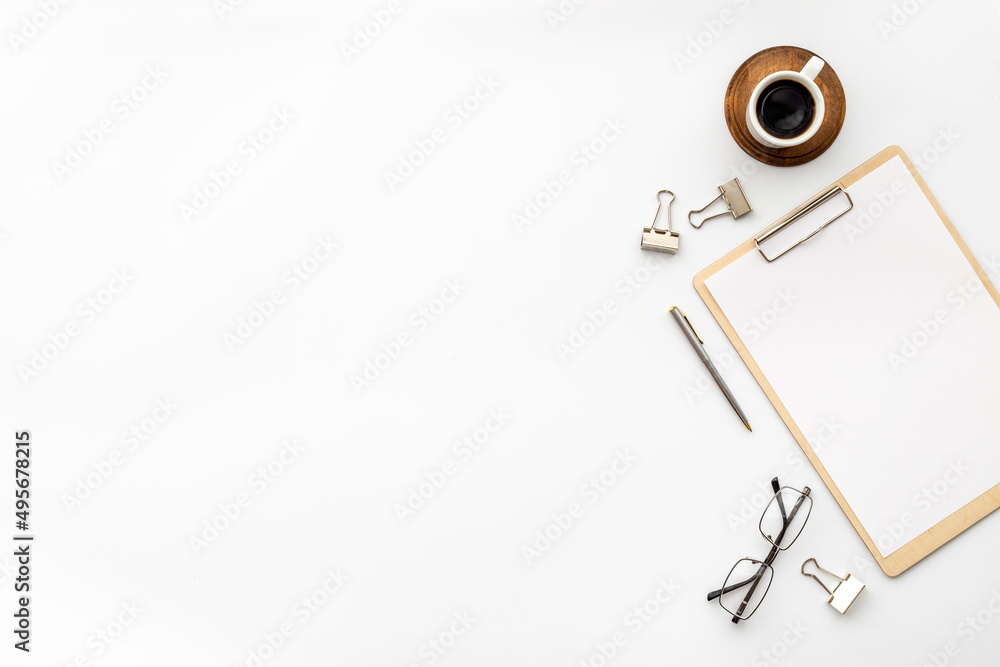 White office desk table with empty paper on clipboard