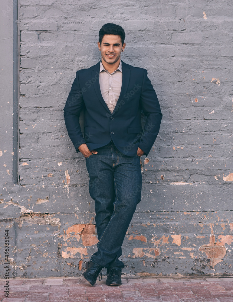 Success looks this good. Portrait of a handsome young businessman standing against a face brick wall