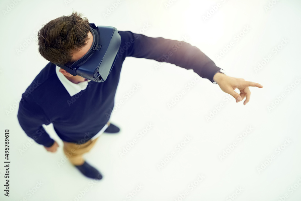 Logged in to the virtual world. High angle shot of a businessman wearing a VR headset while connecti