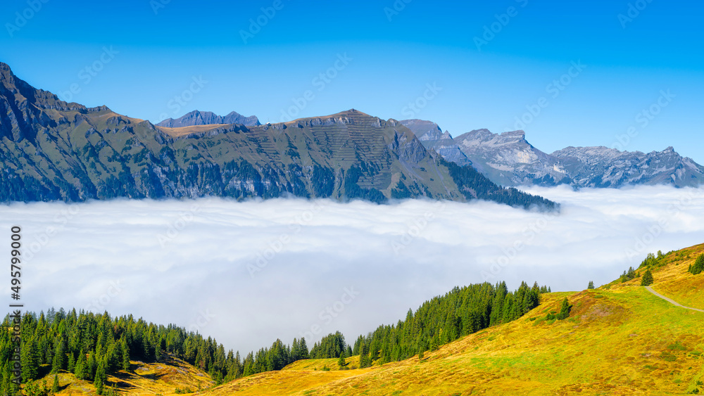 Nature. Mountain range through the clouds. Field and forest. Landscape in the summertime. Large reso