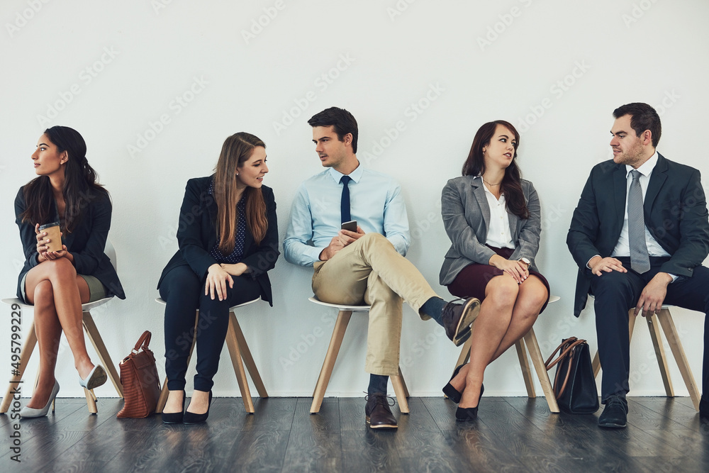 Connecting with the competition. Studio shot of a group of businesspeople talking while waiting in l