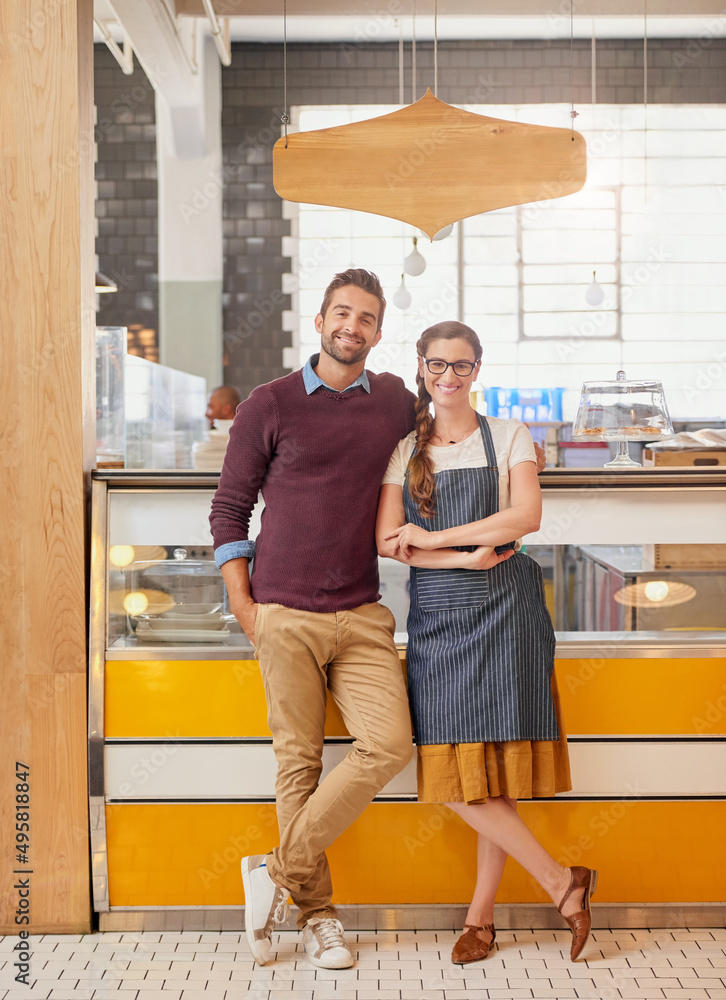 Hard work brought us this far. Portrait of two young business owners posing in front of the counter 