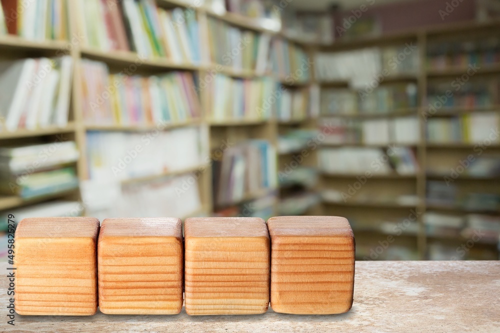 Wooden irregular blocks for letters on library background