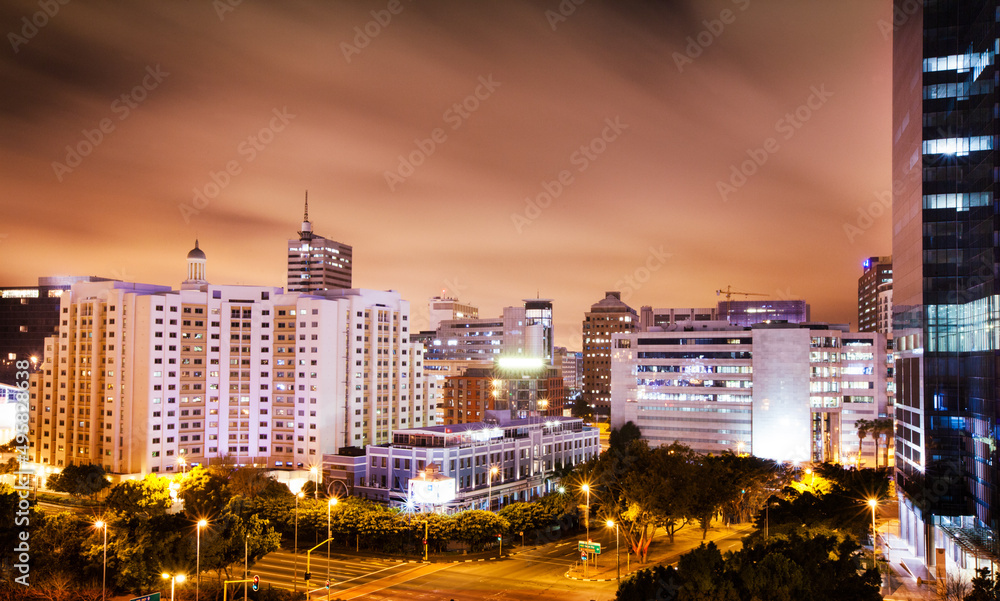 Twilight descends on the city. Shot of a city with lights coming on as the sky turns dark.