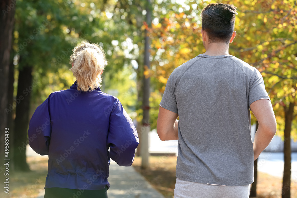 Sporty young couple running in park