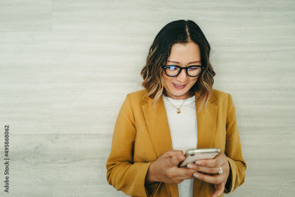 Happy female entrepreneur reading a text message in an office