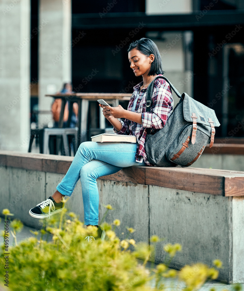 给同学发短信加入她的行列。一名年轻女学生在营地外使用手机的照片