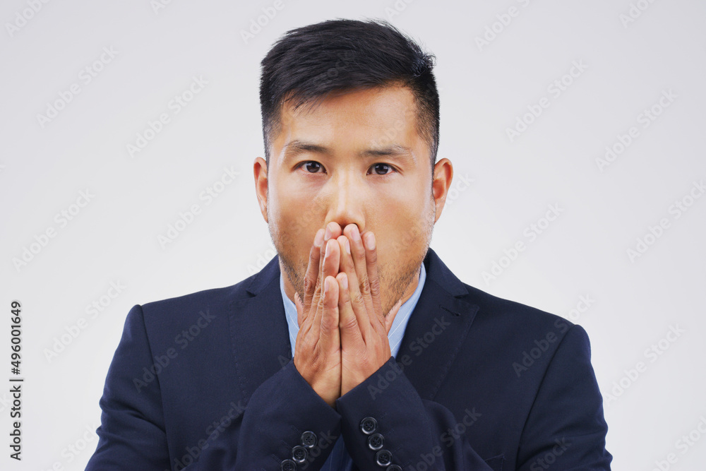 I messed up big time. Studio shot of a young man looking shocked against a grey background.