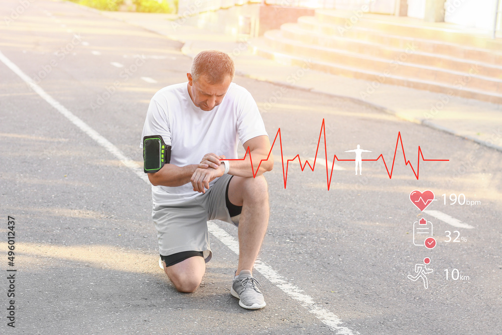 Mature male runner checking pulse outdoors