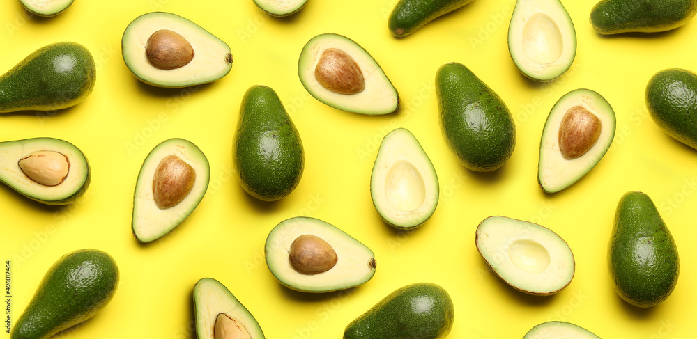 Many ripe avocados on yellow background