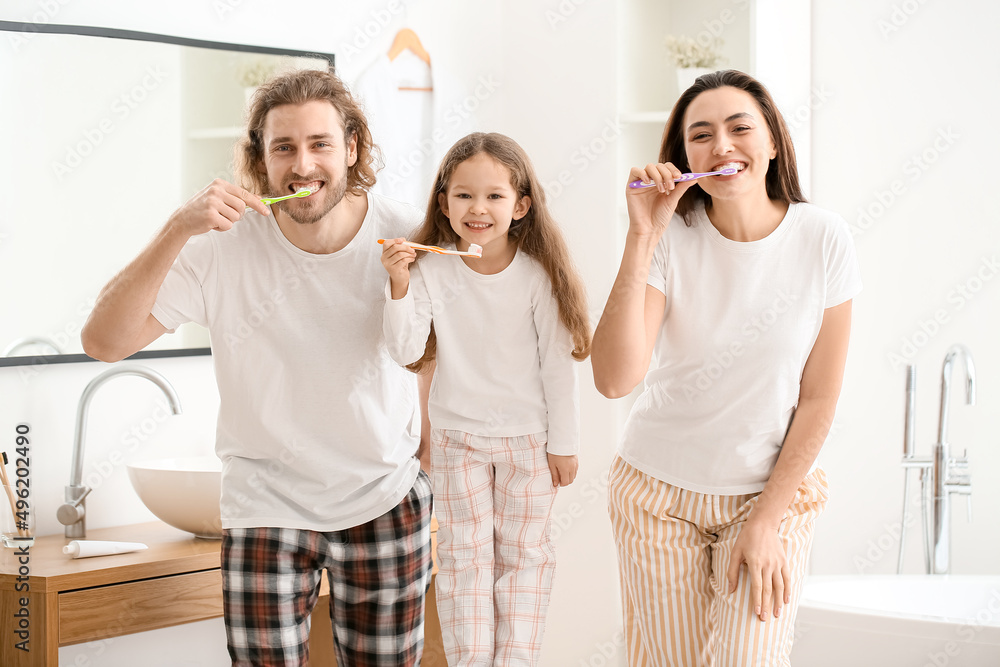 Happy family brushing teeth in bathroom