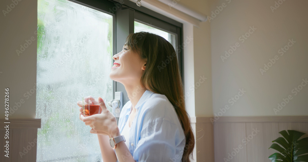 女人透过下雨的窗户看