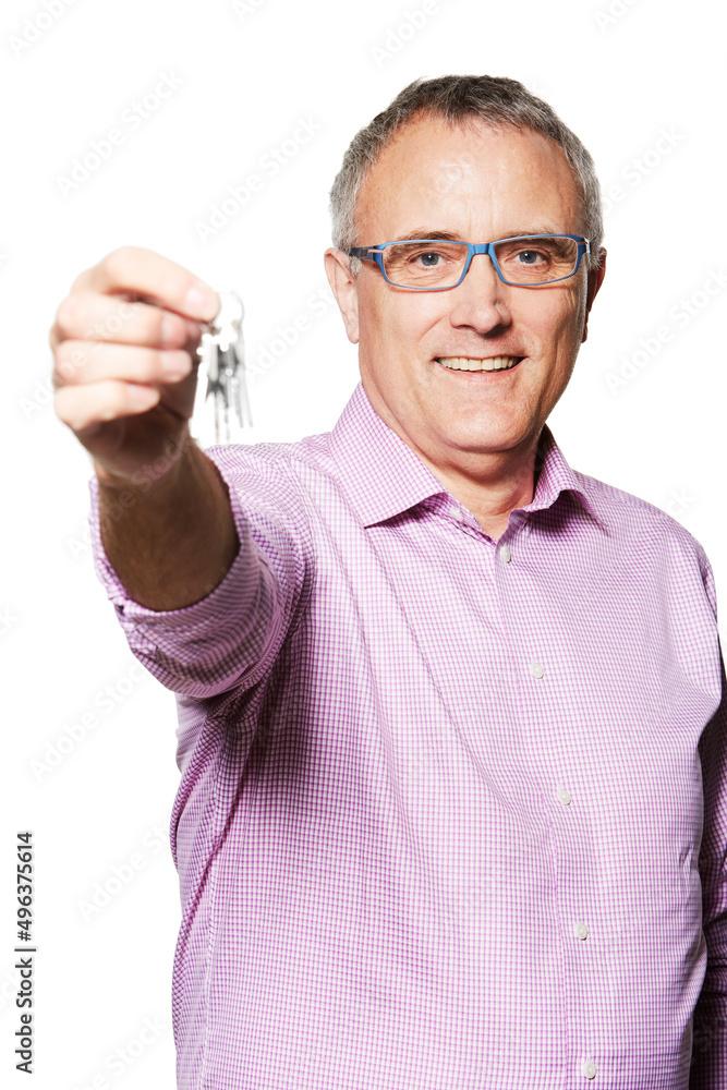 They are all yours. Studio portrait of a mature man holding keys up to the camera.